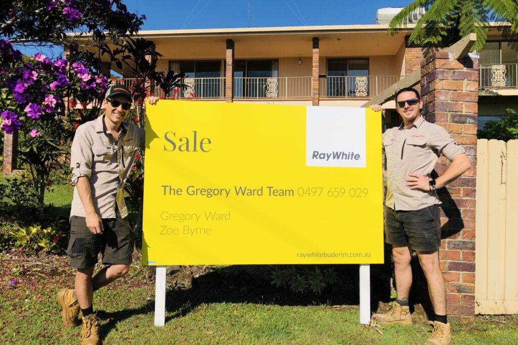 two workers leaning on a sign after a deceased estate clearance